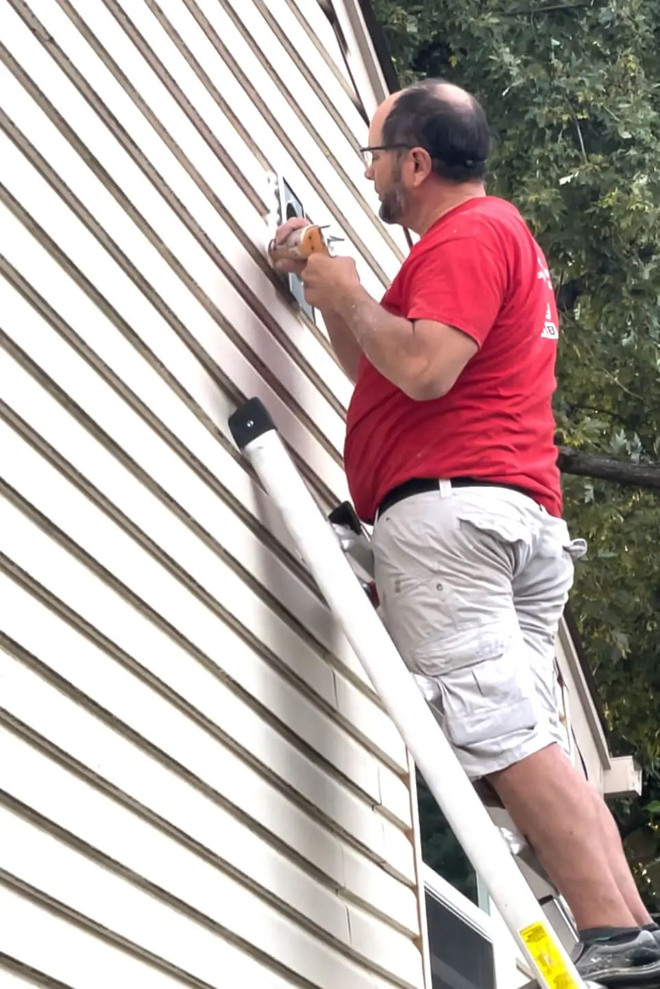 Caulking around the exterior vent cover for DIY stone range hood.